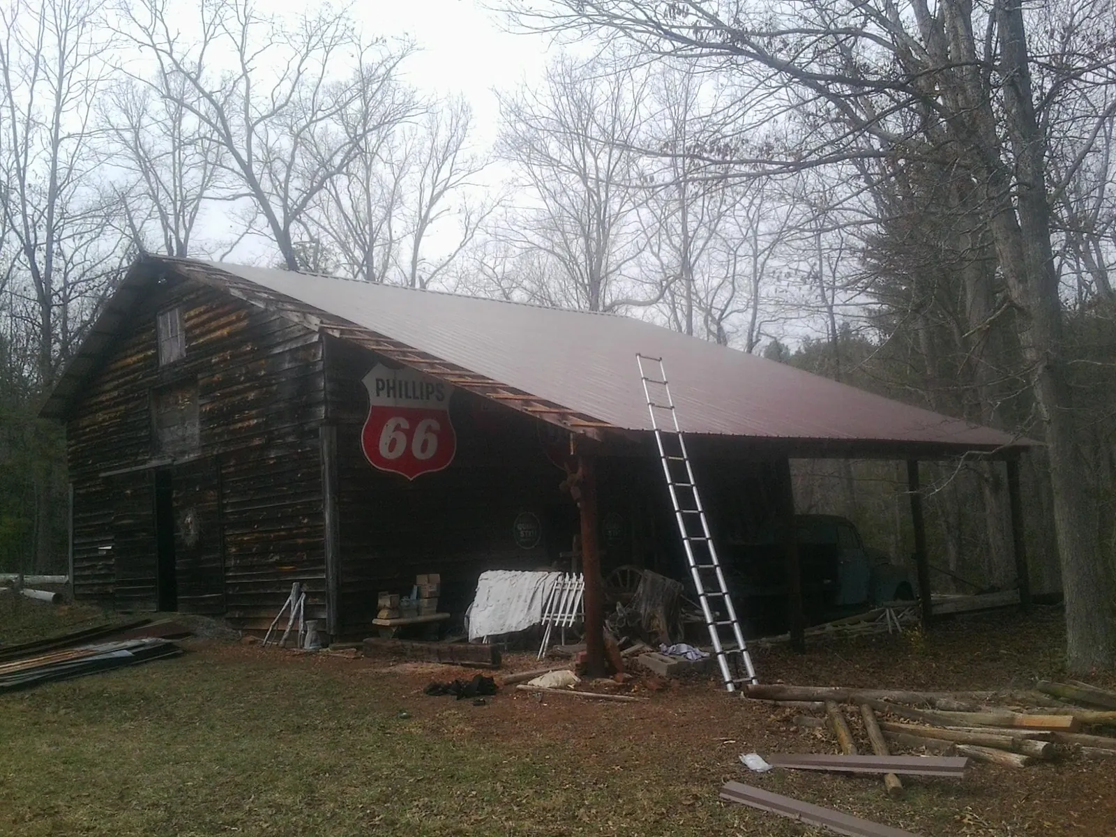 New metal roof on an open sided timber barn with a vintage sign in Cowansville
