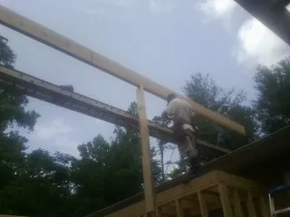Carpenter setting a ridge beam over a new addition frame — Ice Dam Removal by Roofing Brothers in Cowansville