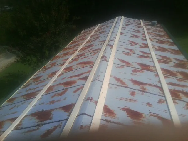 Rusted metal roof panels with new wood purlins before replacement — Storm Damage Roof Repair in Cowansville by Roofing Brothers
